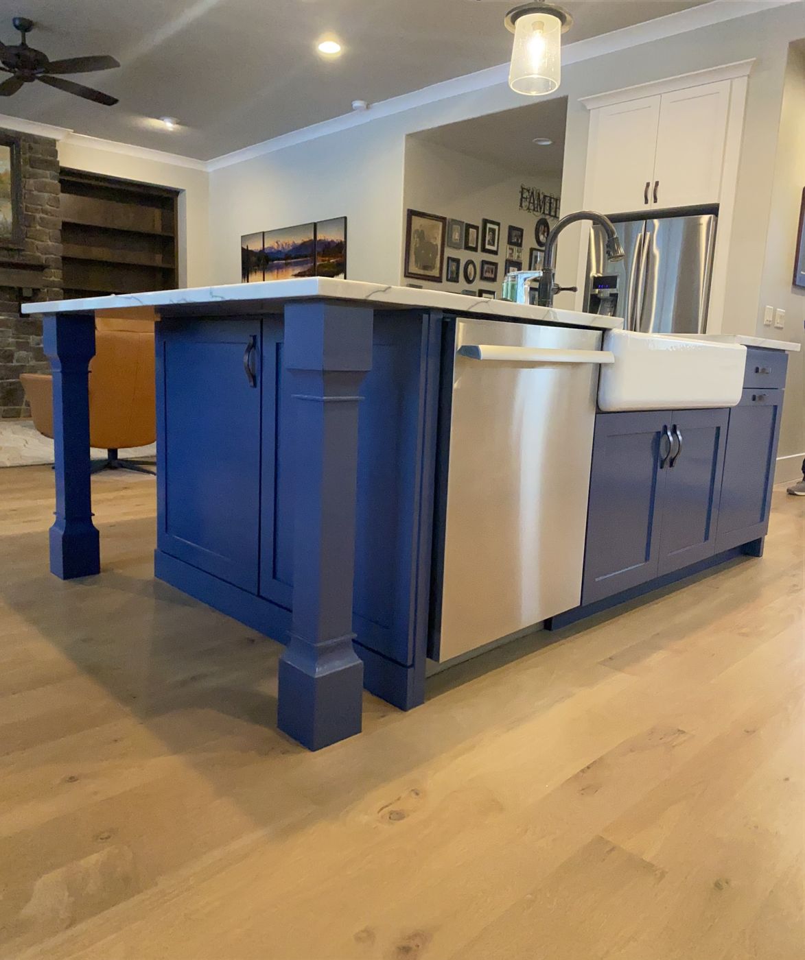 Kitchen island painted deep blue beside white cabinets