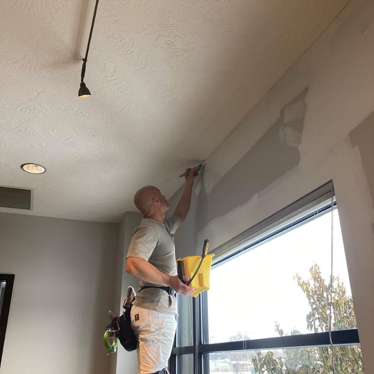 Paul cutting in along a ceiling line with a brush